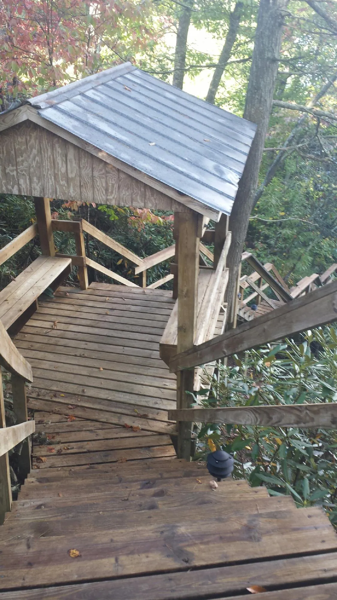 Metal roofed shelter over wooden steps on a wooded walkway — Skylight Repair & Installation work by our crew in Dover